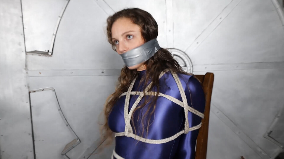 Amber Jonez wearing a shiny Amoresy bodysuit asks her photographer to tie and gag her for a bondage photoshoot