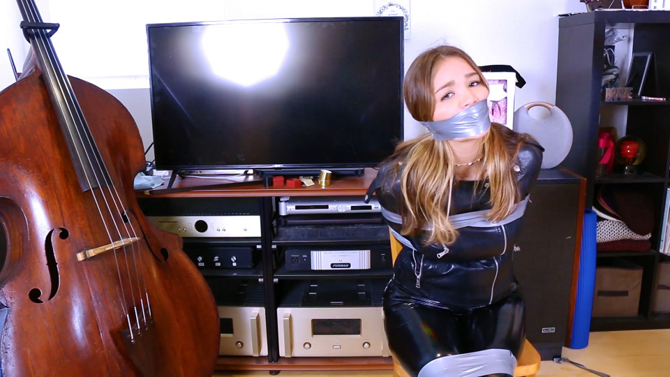 Catburglar Jade Kinsley falls again! Now tightly wraparound tape gagged and tied to a chair wearing a full leather outfit!